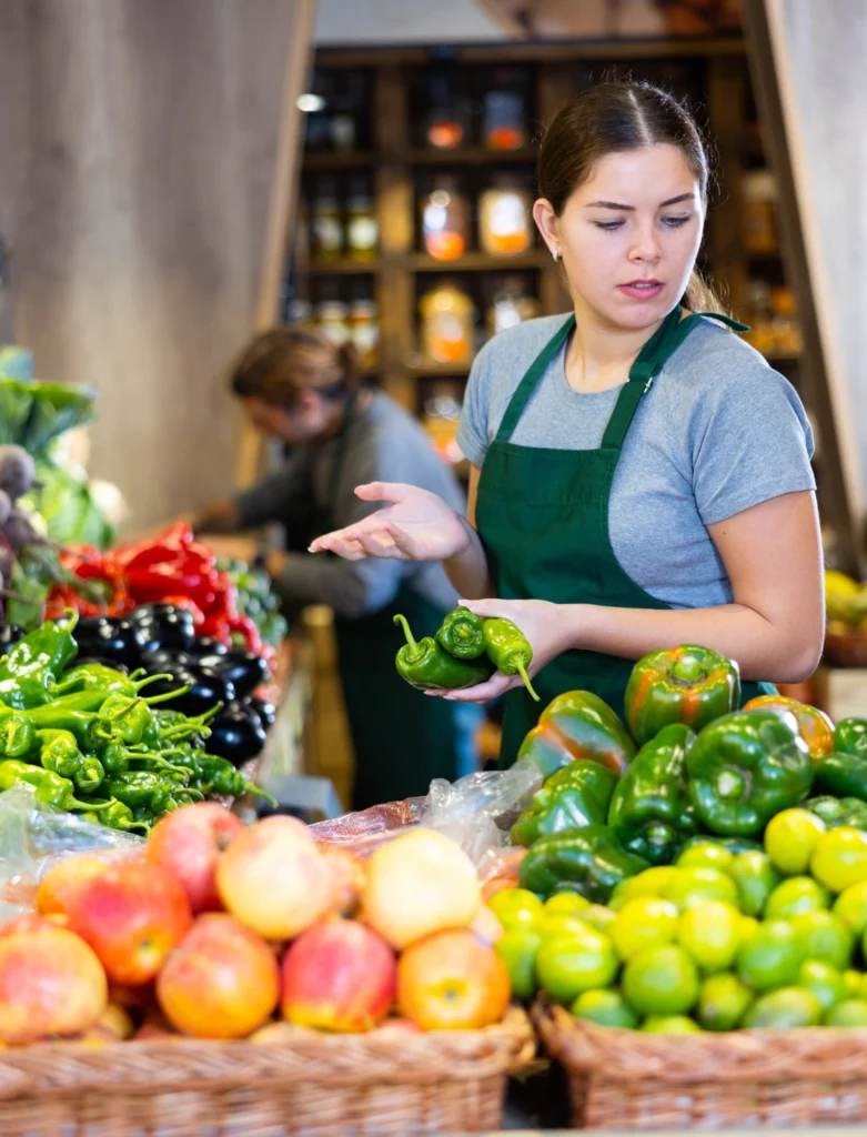 Negoziante controlla disponibilità di verdura nello specifico reparto