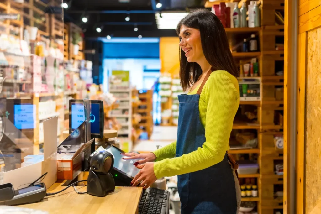 Negoziante sorridente alla cassa