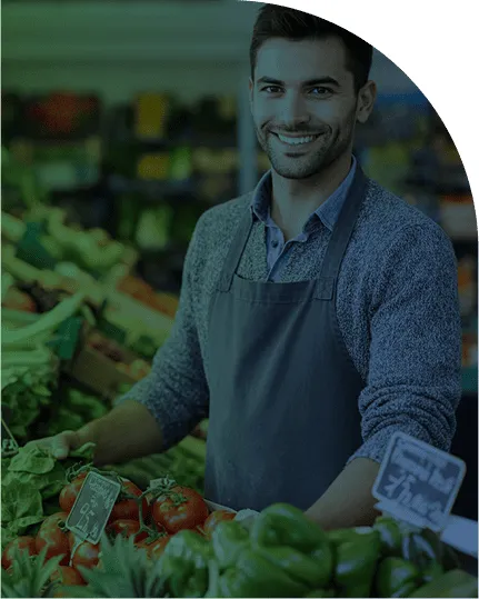 Negoziante di frutta e verdura in un banco di ortofrutta